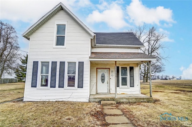 225 2nd St, Latty, OH 45855 - traditional-style home with a porch, roof with shingles, and a front yard