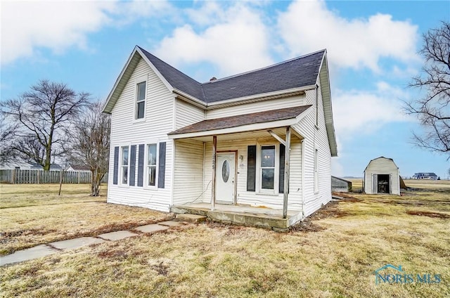 225 2nd St, Latty, OH 45855 - traditional home featuring covered porch, a storage unit, and a shingled roof
