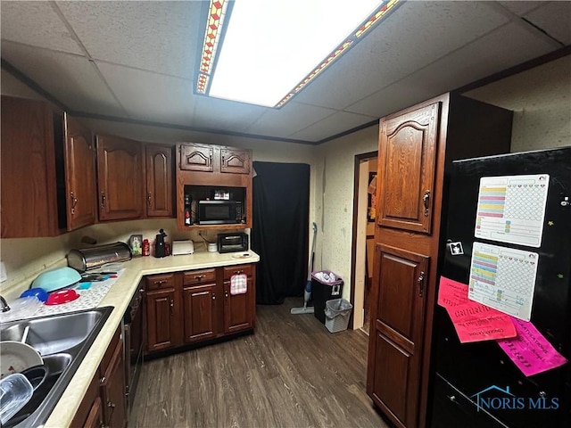 609 E Broadway St, Toledo, OH 43605 - kitchen with black microwave, light countertops, dark wood finished floors, and a drop ceiling