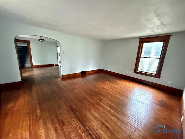 223 E Leggett St, Wauseon, OH 43567 - unfurnished room featuring arched walkways and dark wood finished floors