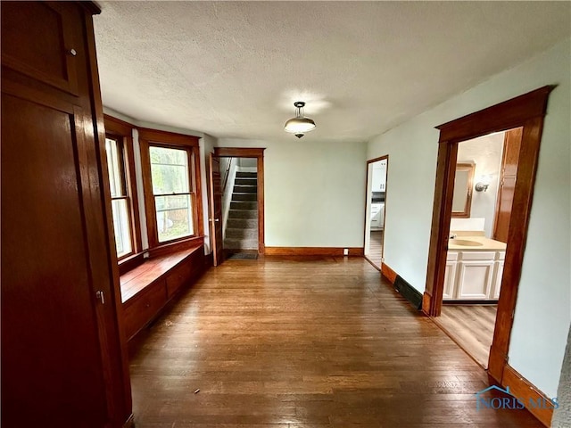 223 E Leggett St, Wauseon, OH 43567 - spare room with stairs, dark wood finished floors, and a textured ceiling