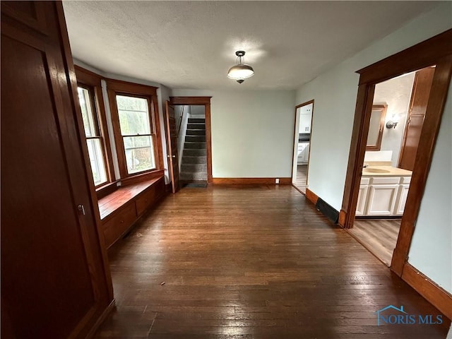 223 E Leggett St, Wauseon, OH 43567 - spare room featuring stairs, dark wood-style floors, and a textured ceiling