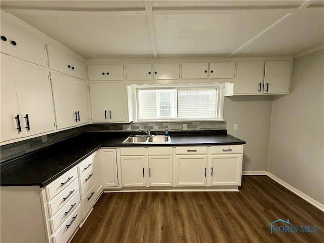 223 E Leggett St, Wauseon, OH 43567 - kitchen with dark countertops, dark wood-style floors, white cabinetry, and decorative backsplash
