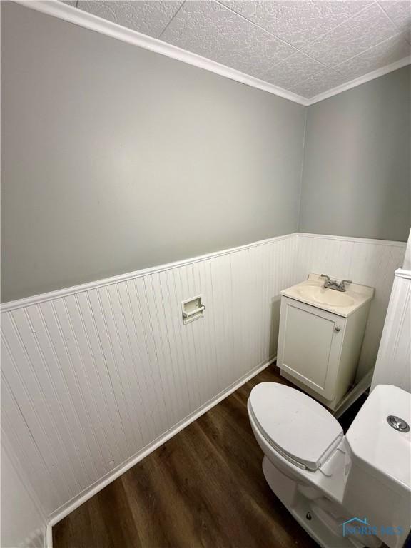 223 E Leggett St, Wauseon, OH 43567 - bathroom featuring wood finished floors, wainscoting, and ornamental molding