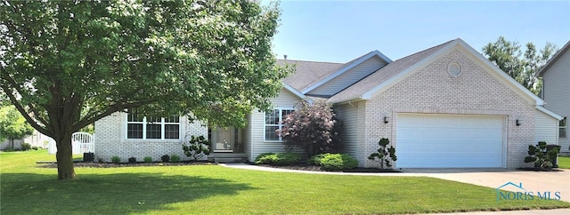 149 Carlee Ln, Findlay, OH 45840 - view of front of house featuring brick siding, a garage, concrete driveway, and a front lawn