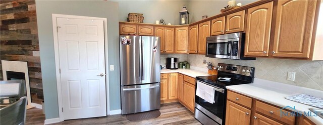 149 Carlee Ln, Findlay, OH 45840 - kitchen with stainless steel appliances, decorative backsplash, wood finished floors, and light countertops