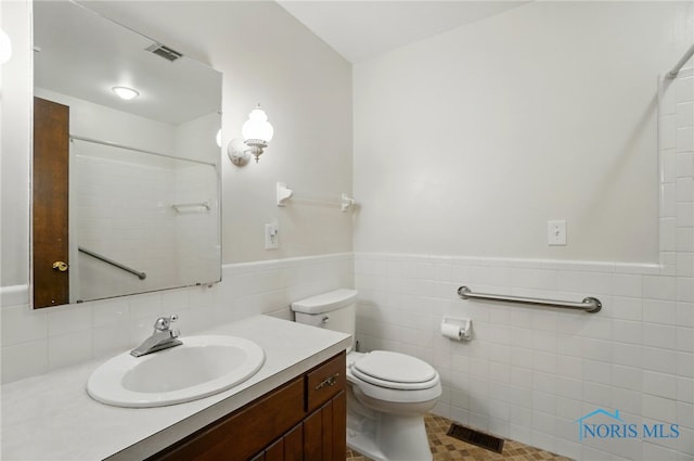 1110 Bourgogne Ave, Bowling Green, OH 43402 - full bath with tile walls, vanity, a wainscoted wall, and a shower