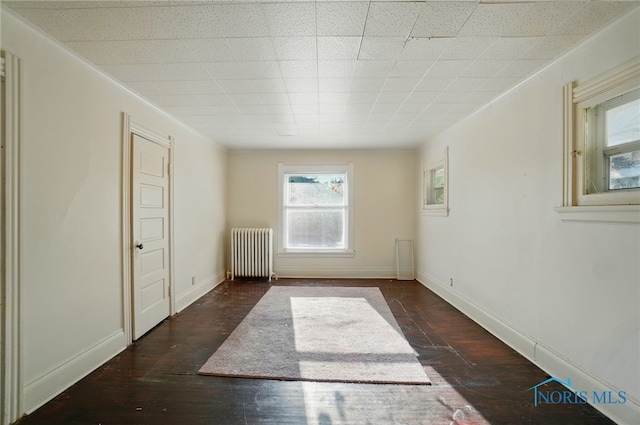 2727 Robinwood Ave, Toledo, OH 43610 - empty room with radiator heating unit, healthy amount of natural light, and dark wood finished floors