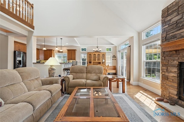 440 W 3rd St, Perrysburg, OH 43551 - living room with a stone fireplace, high vaulted ceiling, a chandelier, and light wood-type flooring