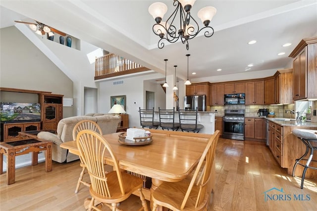 440 W 3rd St, Perrysburg, OH 43551 - dining area with light wood-style flooring, a chandelier, recessed lighting, and a high ceiling