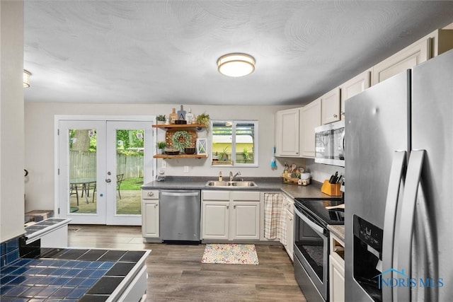 4252 Foxchapel Rd, Toledo, OH 43607 - kitchen featuring stainless steel appliances, dark countertops, dark wood finished floors, and french doors