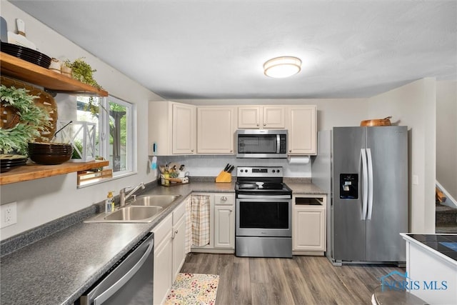 4252 Foxchapel Rd, Toledo, OH 43607 - kitchen featuring stainless steel appliances, wood finished floors, open shelves, and dark countertops