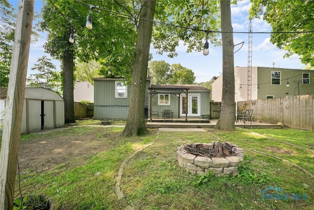 4252 Foxchapel Rd, Toledo, OH 43607 - rear view of house with a fire pit, a storage shed, a deck, and a fenced backyard