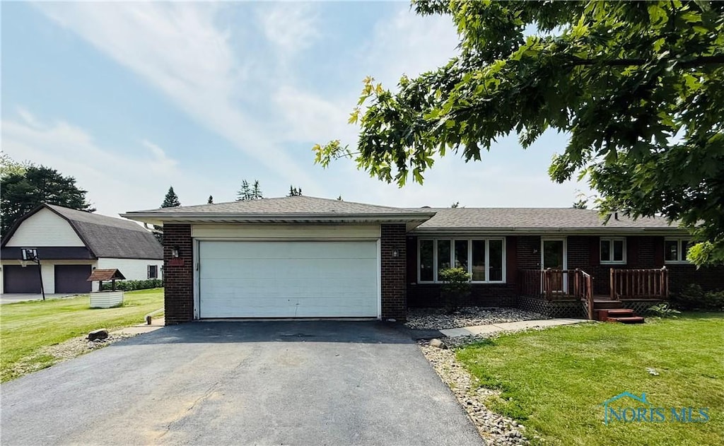 17715 Mitchell Rd, Bowling Green, OH 43402 - ranch-style home featuring driveway, a garage, a front yard, and brick siding