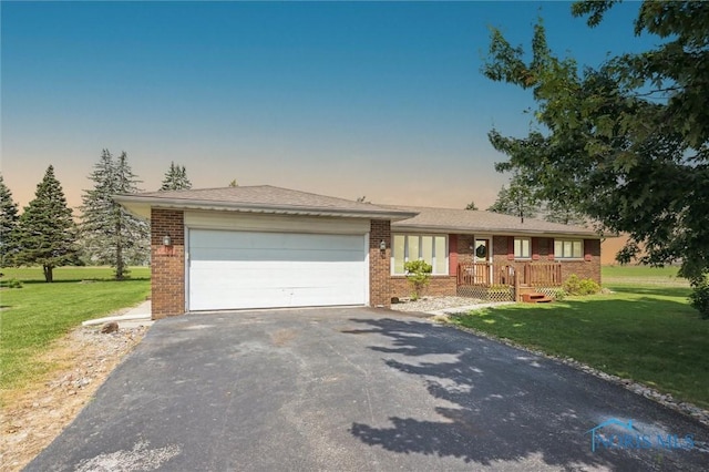 17715 Mitchell Rd, Bowling Green, OH 43402 - view of front of house with driveway, brick siding, and a yard