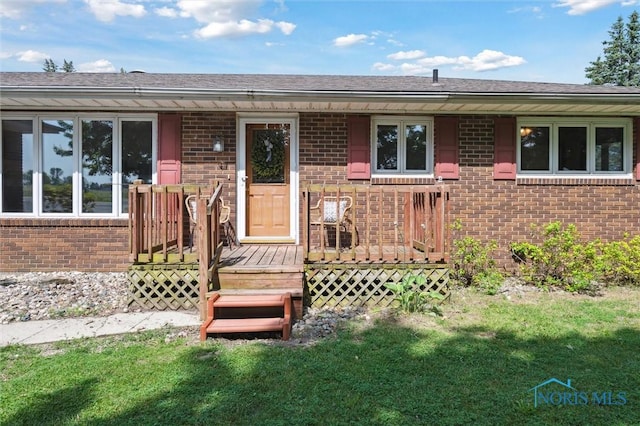 17715 Mitchell Rd, Bowling Green, OH 43402 - view of front of home with brick siding, a front yard, and a wooden deck