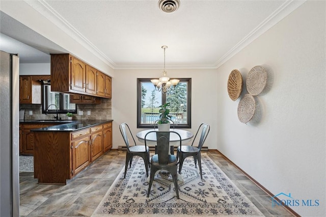 17715 Mitchell Rd, Bowling Green, OH 43402 - dining space featuring a chandelier, stone finish flooring, and crown molding