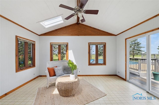 17715 Mitchell Rd, Bowling Green, OH 43402 - living area featuring a skylight, vaulted ceiling, ceiling fan, wood walls, and crown molding