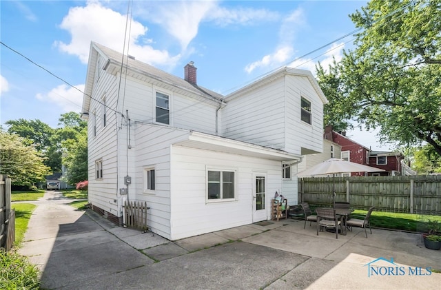3743 Woodmont Rd, Toledo, OH 43613 - rear view of house featuring a patio area, a chimney, and outdoor dining area