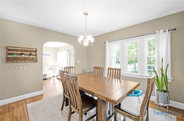3743 Woodmont Rd, Toledo, OH 43613 - dining area with arched walkways, wood finished floors, and a chandelier