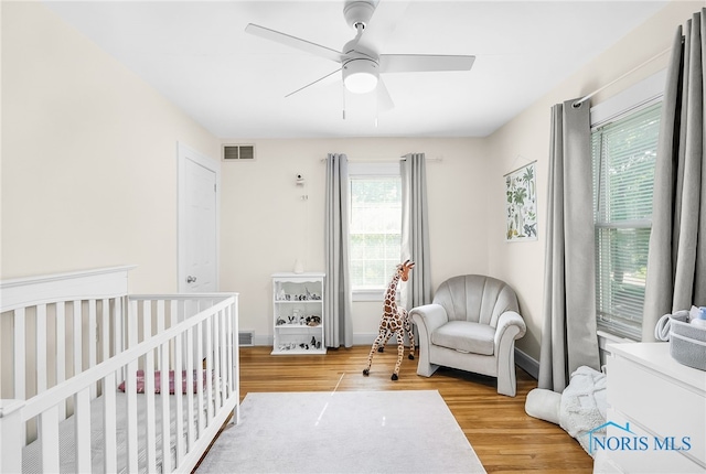 3743 Woodmont Rd, Toledo, OH 43613 - bedroom featuring light wood-type flooring, a crib, and a ceiling fan