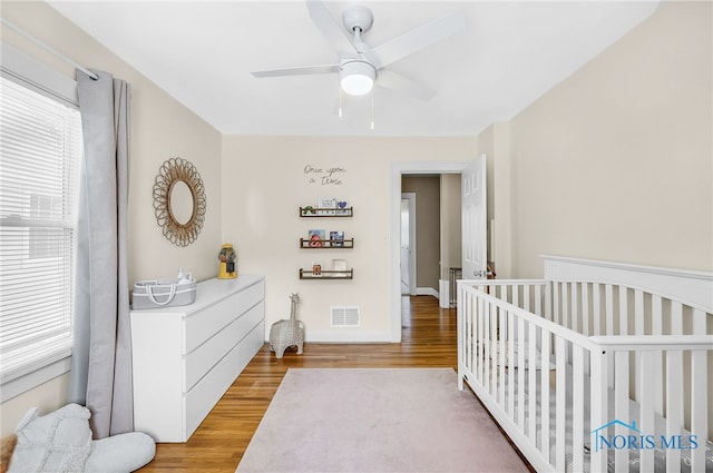 3743 Woodmont Rd, Toledo, OH 43613 - bedroom with light wood finished floors, a crib, and a ceiling fan