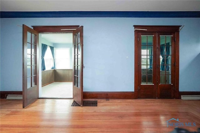 12044 W Duff Washa Rd, Oak Harbor, OH 43449 - unfurnished room featuring french doors, a baseboard radiator, and wood finished floors