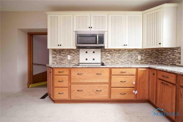 12044 W Duff Washa Rd, Oak Harbor, OH 43449 - kitchen with stainless steel microwave, backsplash, and light stone counters