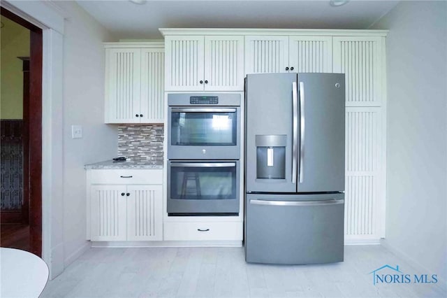 12044 W Duff Washa Rd, Oak Harbor, OH 43449 - kitchen with stainless steel appliances, tasteful backsplash, white cabinets, and light wood-style floors