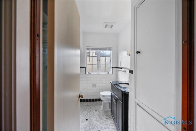 3740 Mapleway Dr, Toledo, OH 43614 - half bath featuring tile patterned flooring, tile walls, vanity, and wainscoting