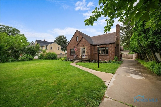 3740 Mapleway Dr, Toledo, OH 43614 - english style home with brick siding, a chimney, and driveway