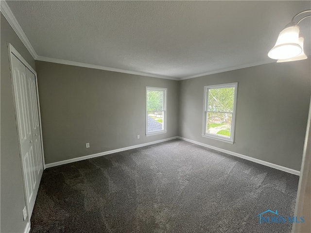 4032 Burnham Ave, Toledo, OH 43612 - unfurnished bedroom featuring ornamental molding, dark carpet, a closet, and a textured ceiling