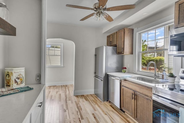 826 4th St, Toledo, OH 43605 - kitchen with appliances with stainless steel finishes, light countertops, ceiling fan, brown cabinets, and light wood finished floors