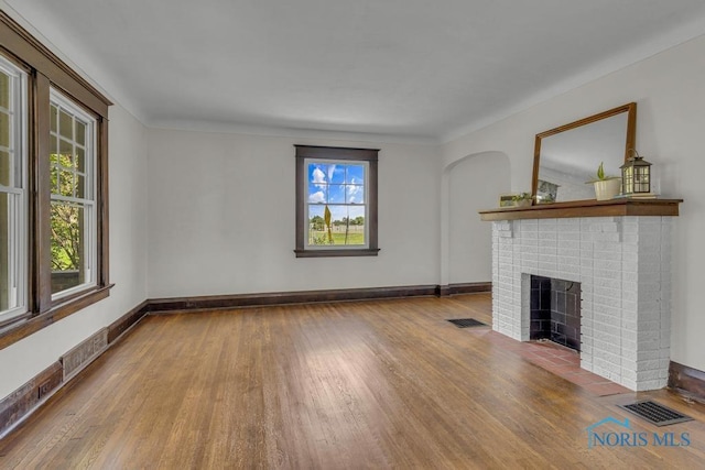 826 4th St, Toledo, OH 43605 - unfurnished living room with wood finished floors and a brick fireplace