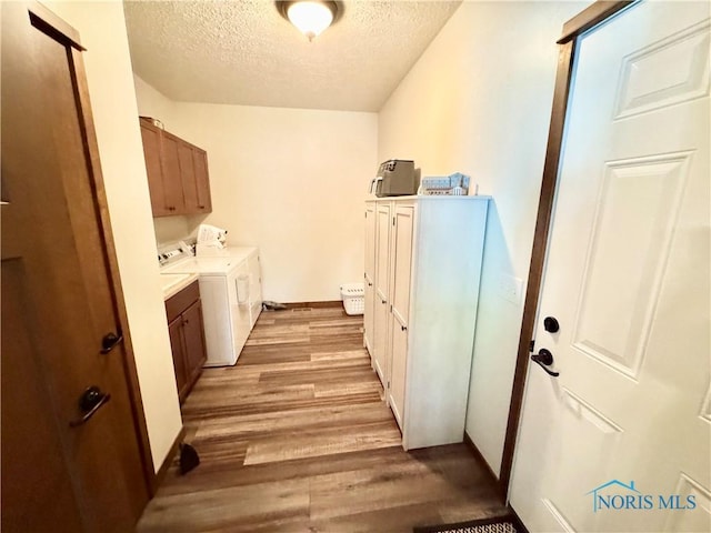 1462 Lee Ann Ave, Defiance, OH 43512 - laundry room with cabinet space, a textured ceiling, independent washer and dryer, and light wood-style floors