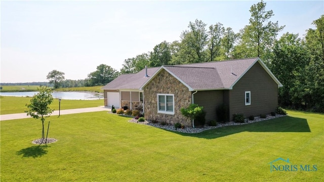 1462 Lee Ann Ave, Defiance, OH 43512 - view of front of property featuring stone siding, a water view, a garage, a front lawn, and driveway