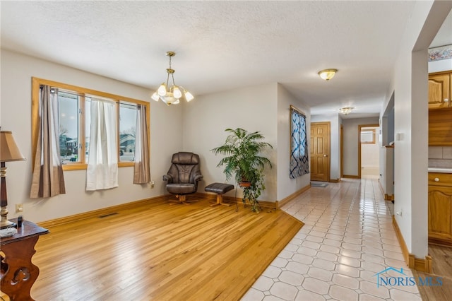 1411 Sawmill Bnd, Findlay, OH 45840 - living area with a chandelier, a textured ceiling, and light wood finished floors