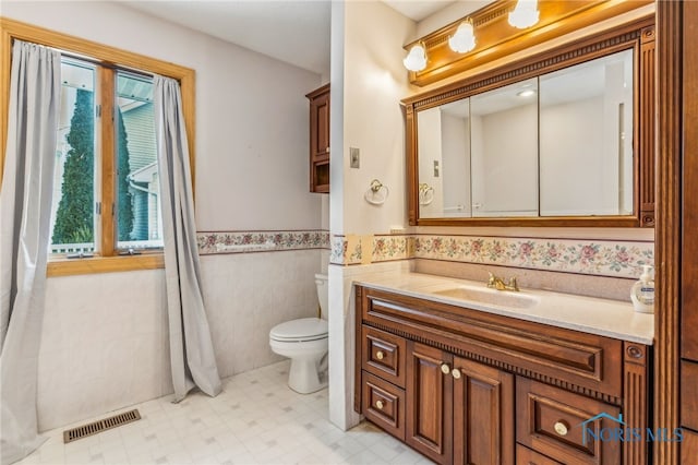 1411 Sawmill Bnd, Findlay, OH 45840 - bathroom featuring vanity, a wainscoted wall, tile walls, and tile patterned floors