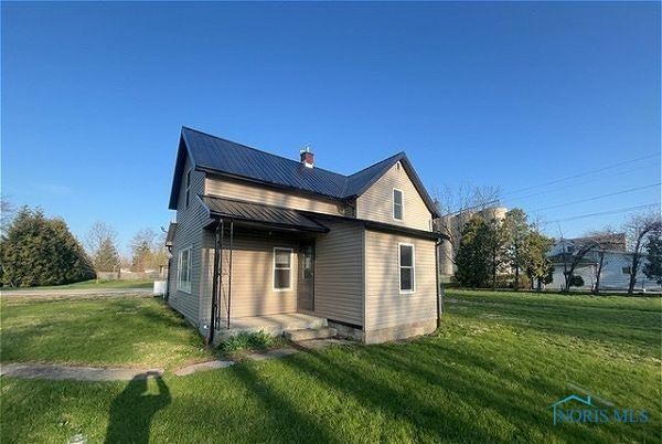102 N Maple St, Payne, OH 45880 - back of house with a lawn, a metal roof, and a chimney