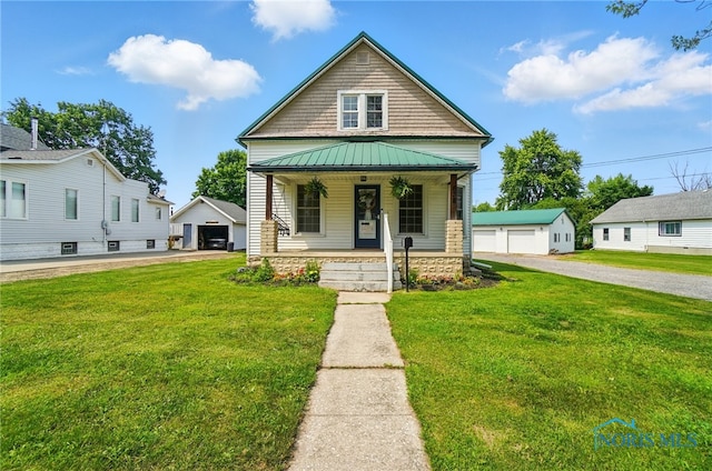 638 W Elm St, Wauseon, OH 43567 - view of front facade featuring covered porch, a garage, an outdoor structure, a front lawn, and a standing seam roof