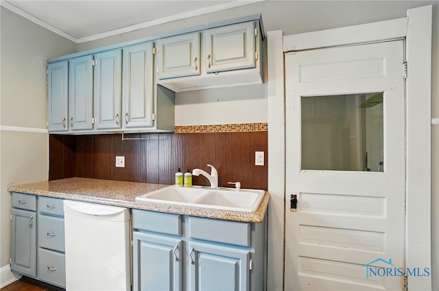 638 W Elm St, Wauseon, OH 43567 - kitchen with white dishwasher, blue cabinetry, light countertops, crown molding, and wood walls