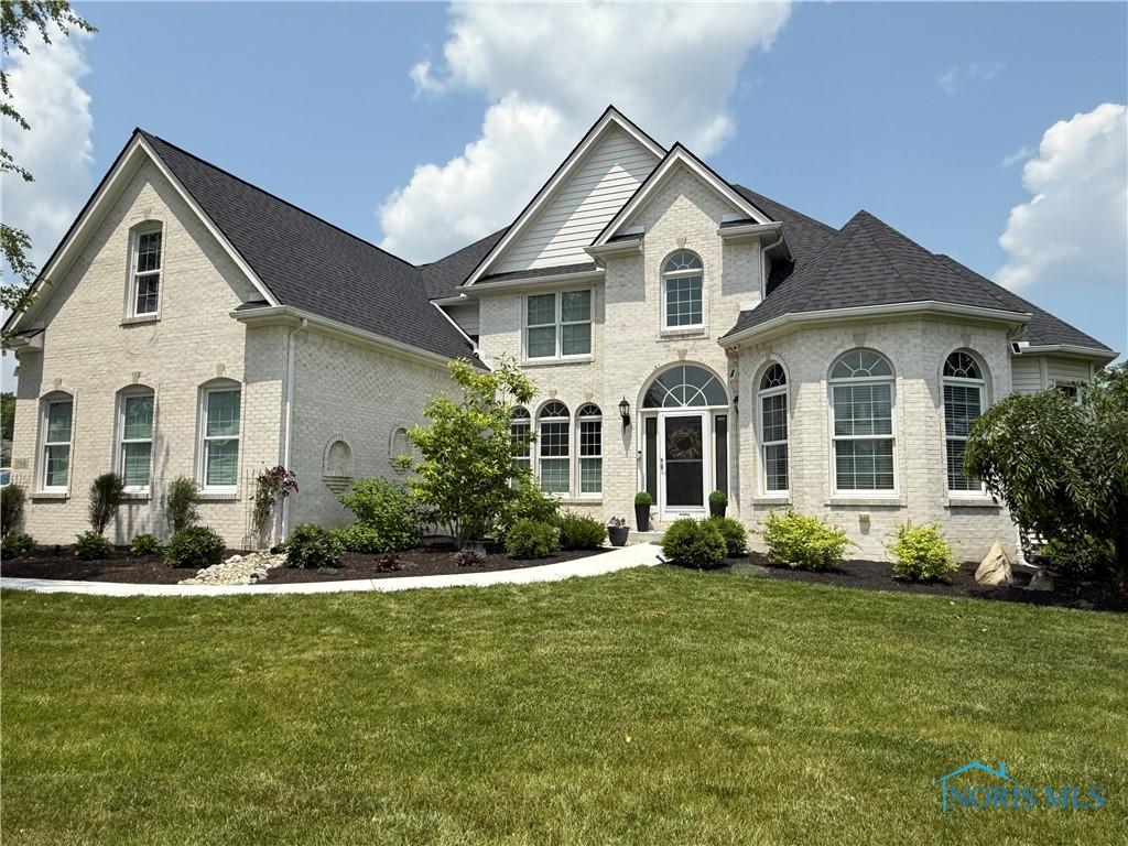 7910 Quail Creek Rd, Maumee, OH 43537 - french provincial home featuring brick siding, a front yard, and roof with shingles