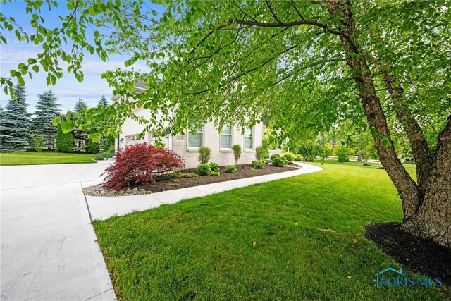 7910 Quail Creek Rd, Maumee, OH 43537 - view of green lawn featuring driveway and a garage
