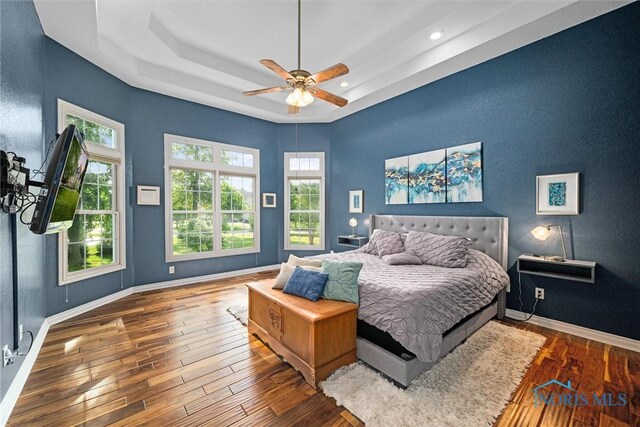 7910 Quail Creek Rd, Maumee, OH 43537 - bedroom with wood-type flooring, multiple windows, a tray ceiling, recessed lighting, and ceiling fan