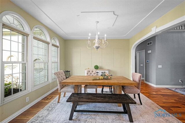 7910 Quail Creek Rd, Maumee, OH 43537 - dining room featuring dark wood-type flooring, a chandelier, and arched walkways