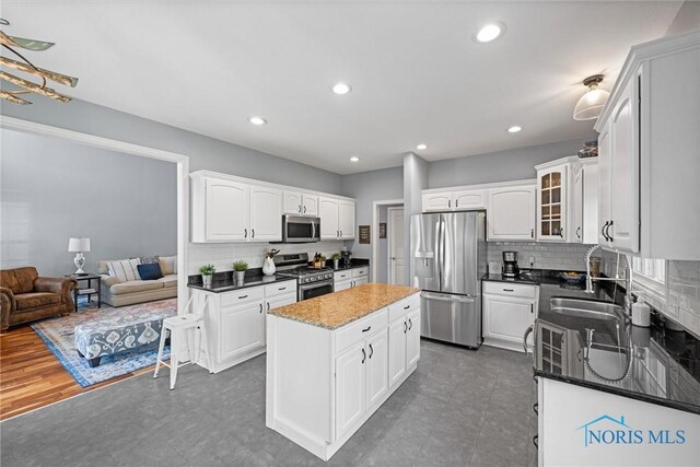 7910 Quail Creek Rd, Maumee, OH 43537 - kitchen featuring appliances with stainless steel finishes, a kitchen island, backsplash, white cabinets, and recessed lighting
