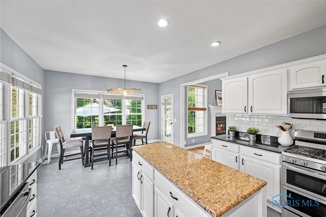 7910 Quail Creek Rd, Maumee, OH 43537 - kitchen with stainless steel appliances, a kitchen island, healthy amount of natural light, white cabinets, and recessed lighting