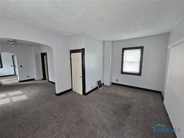 1133 Sherman St, Toledo, OH 43608 - spare room with arched walkways, dark colored carpet, a textured ceiling, and ceiling fan