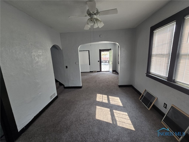 1133 Sherman St, Toledo, OH 43608 - carpeted empty room with arched walkways and ceiling fan