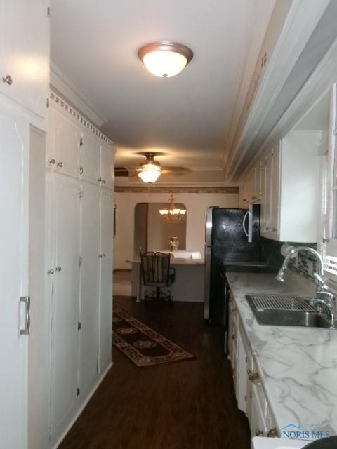 8962 State Route 109, Ottawa, OH 45875 - kitchen featuring ceiling fan, white cabinets, crown molding, light countertops, and dark wood-type flooring
